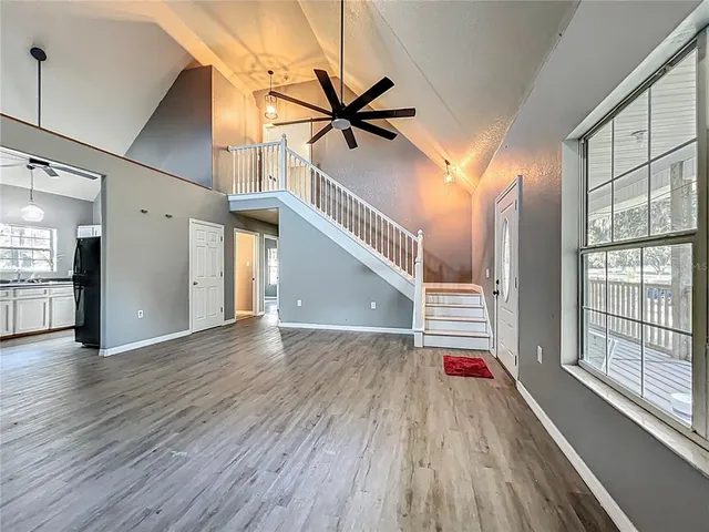 a view of a livingroom with wooden floor and a ceiling fan