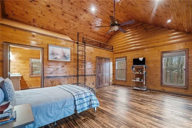 a spacious bedroom with a bed a window and dresser