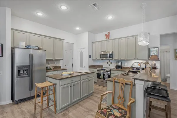 a kitchen that has a lot of cabinets a sink and appliances in it