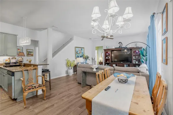 a living room with furniture a flat screen tv and kitchen view