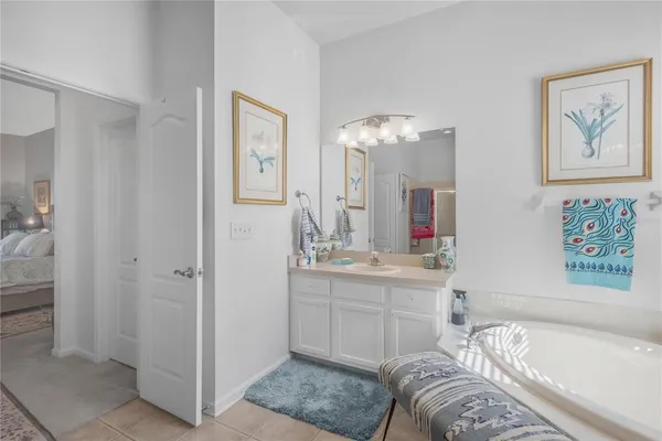 a spacious bathroom with a tub sink and mirror