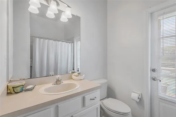 a bathroom with a toilet a sink and mirror