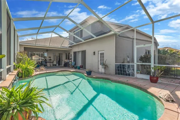 a view of a swimming pool with a patio and a backyard