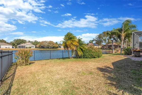 a view of backyard with swimming pool and trees in the background