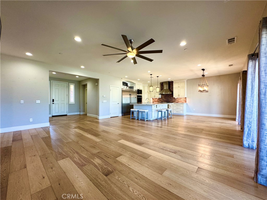 17841 Grapevine Lane San Bernardino, CA 92407 - Photo 15 of 63 a view of a livingroom with a fireplace a chandelier a wooden table and chairs