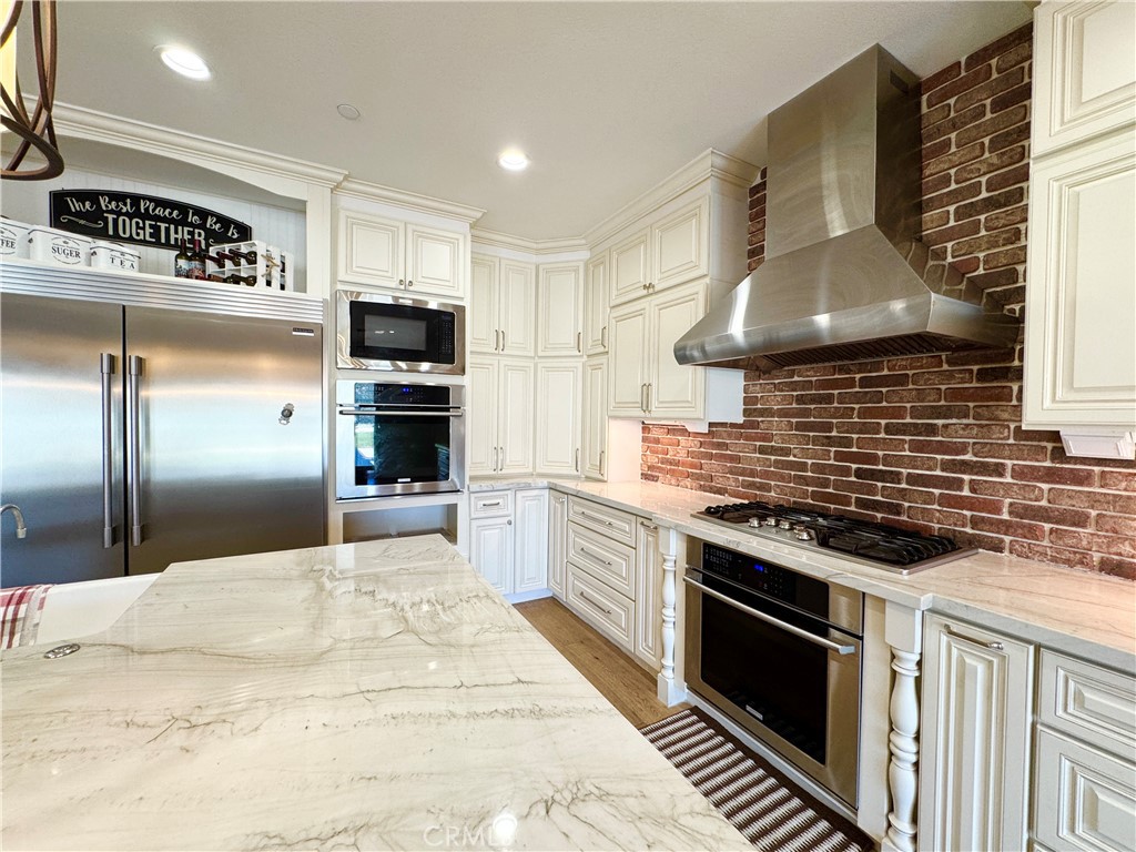 17841 Grapevine Lane San Bernardino, CA 92407 - Photo 21 of 63 a kitchen with stainless steel appliances kitchen island granite countertop a stove and a refrigerator