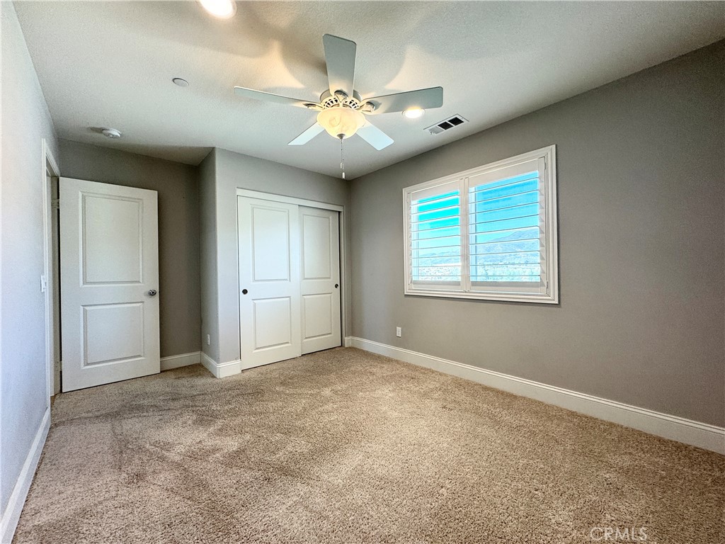 17841 Grapevine Lane San Bernardino, CA 92407 - Photo 54 of 63 an empty room with windows and chandelier fan
