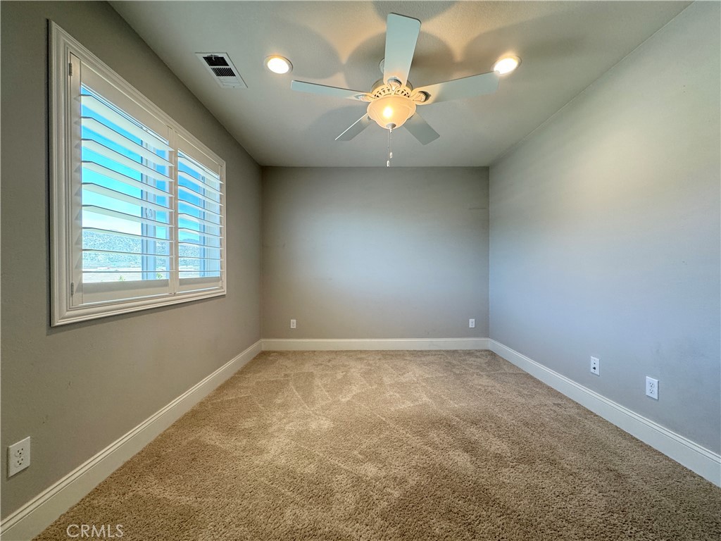 17841 Grapevine Lane San Bernardino, CA 92407 - Photo 56 of 63 an empty room with a chandelier fan and windows