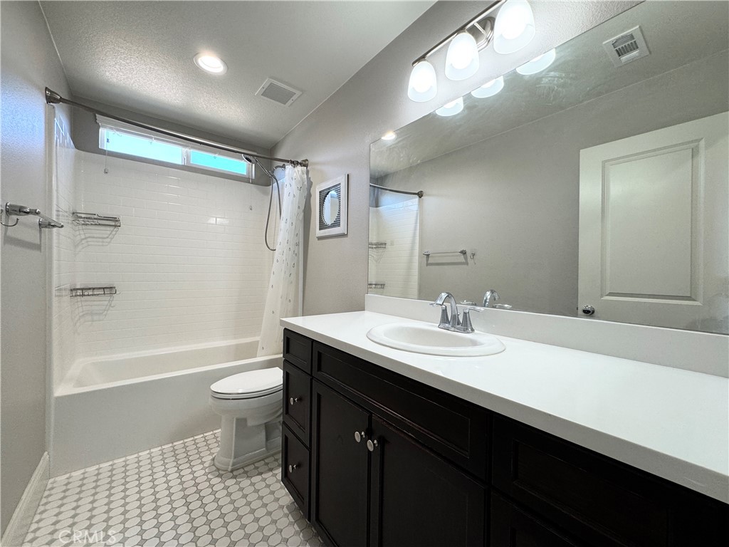 17841 Grapevine Lane San Bernardino, CA 92407 - Photo 57 of 63 a bathroom with a sink a toilet a mirror and shower
