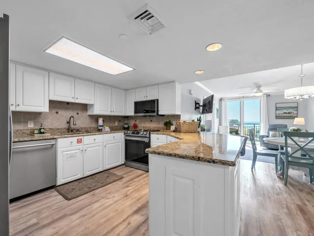a kitchen with granite countertop white cabinets and white appliances