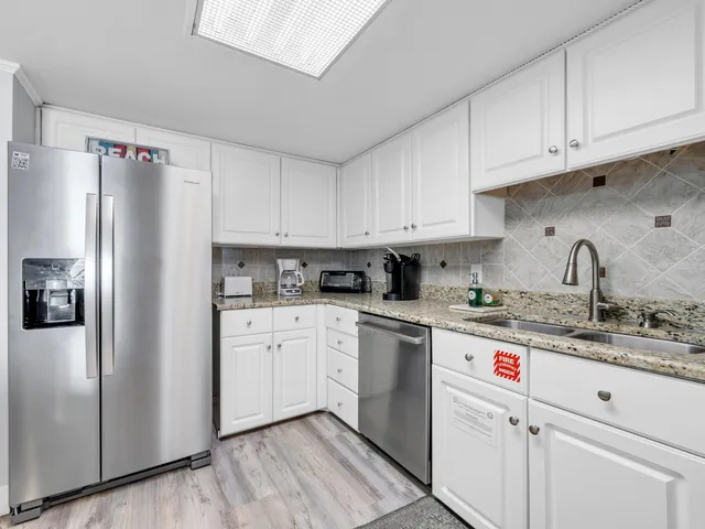 a kitchen with stainless steel appliances granite countertop a refrigerator sink and cabinets
