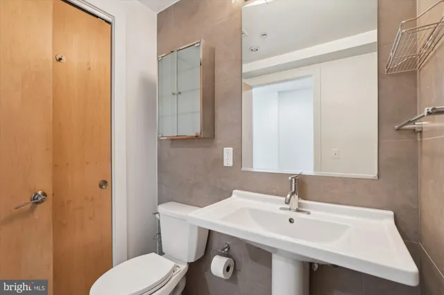 a bathroom with a toilet a sink and mirror