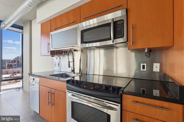 a kitchen with stainless steel appliances granite countertop a stove and a microwave