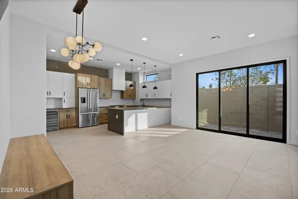 a large white kitchen with a stove a sink dishwasher and a refrigerator with wooden floor