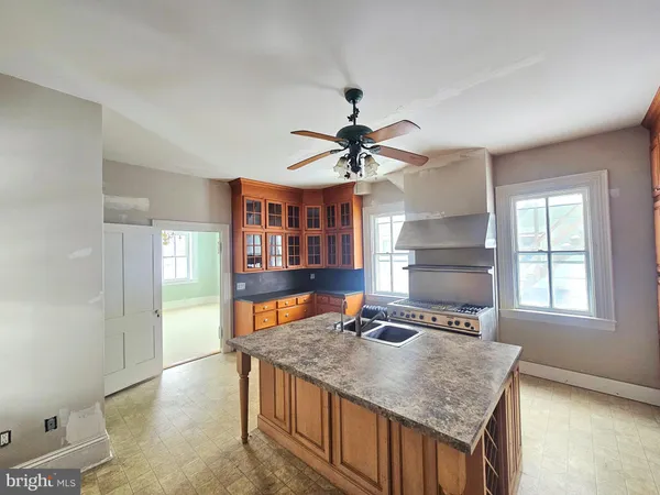 a kitchen with a stove top oven a sink a dining table and chairs