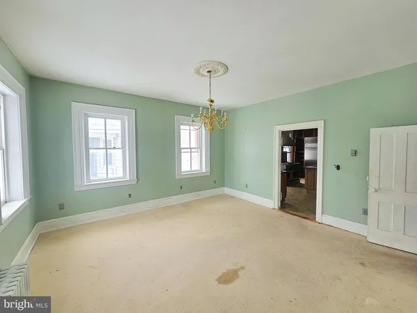 a view of an empty room with window and closet area