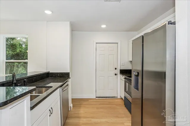 a kitchen with a refrigerator and a stove top oven