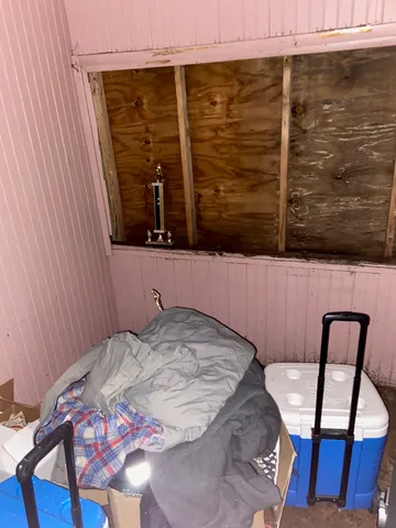 a bedroom with a bed and a chair with the wooden floor