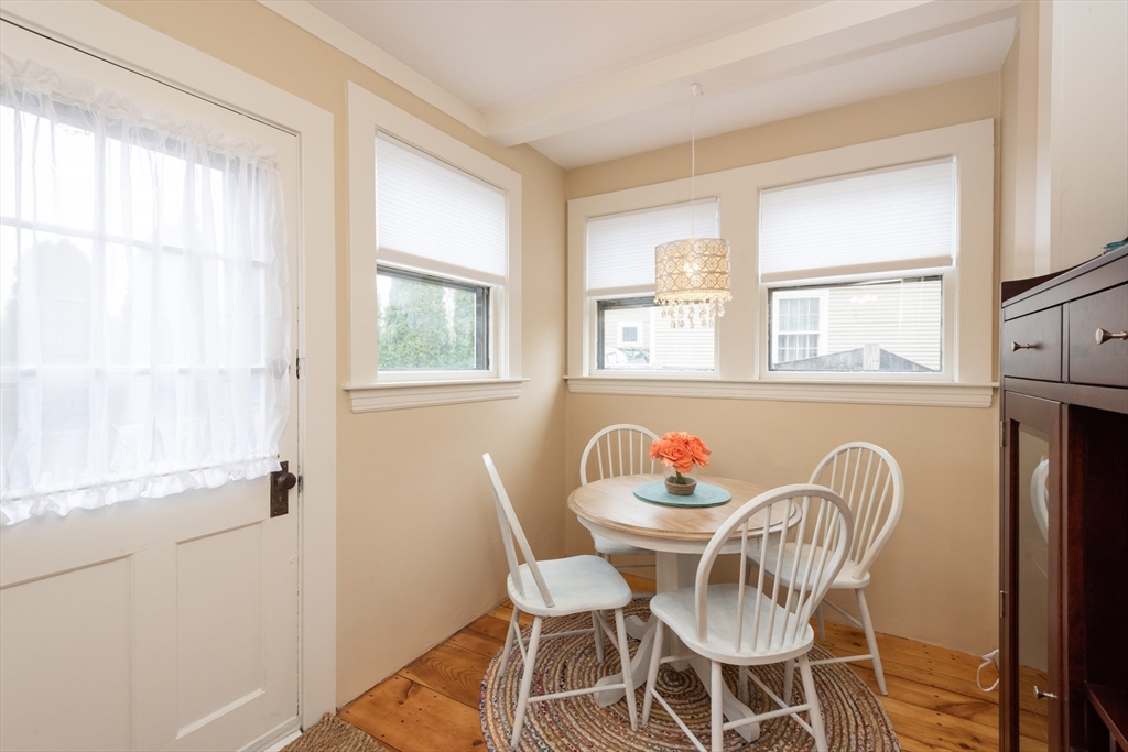 55 Linebrook Road, Unit 1 Ipswich, MA 01938 - Photo 16 of 25 a dining room with furniture a chandelier and wooden floor