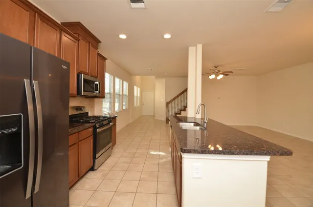 a kitchen with stainless steel appliances granite countertop a sink a stove and a refrigerator