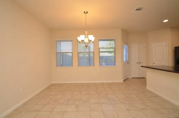 a view of an empty room with window and cabinet