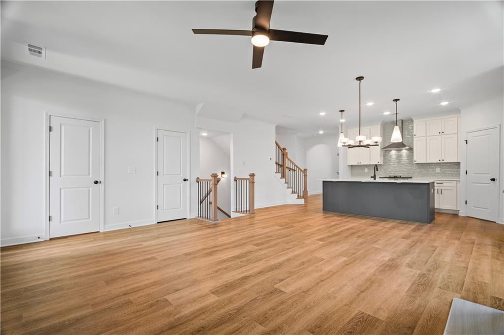 201 Retreat Lane Canton, GA 30114 - Photo 11 of 43 a view of a kitchen with kitchen island a sink wooden floor and a counter top space