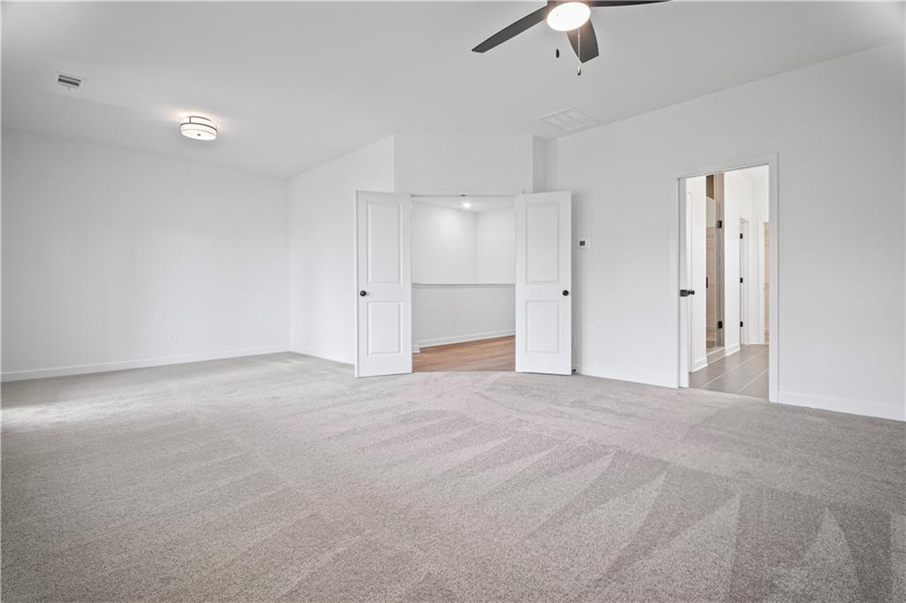 201 Retreat Lane Canton, GA 30114 - Photo 18 of 43 a view of an empty room with a ceiling fan window and a ceiling fan