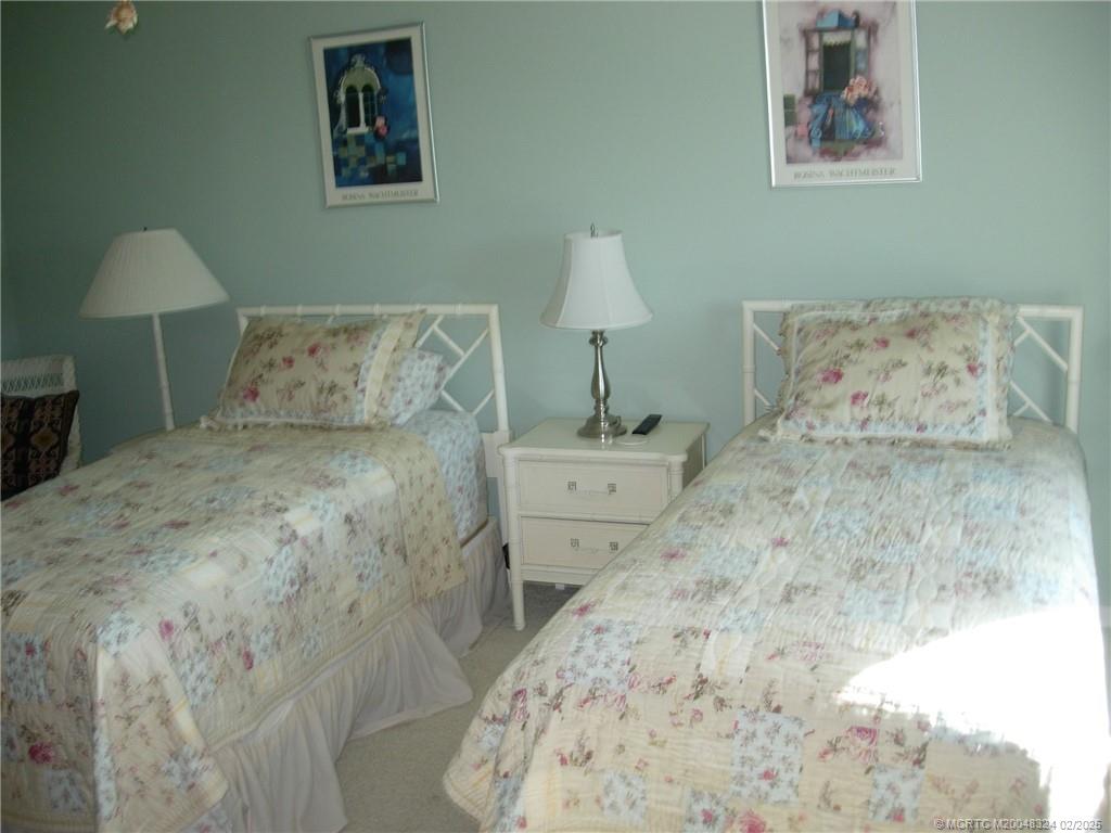 2641 Northeast Ocean Boulevard, Unit 201 Stuart, FL 34996 - Photo 11 of 34 a bedroom with a bed and a lamp on dresser