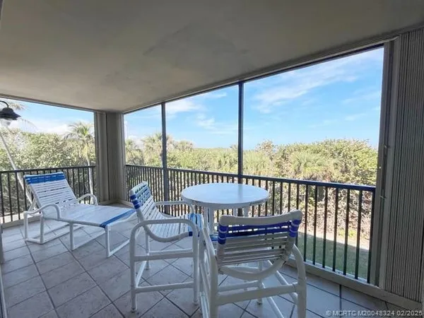a view of a balcony with chair and table