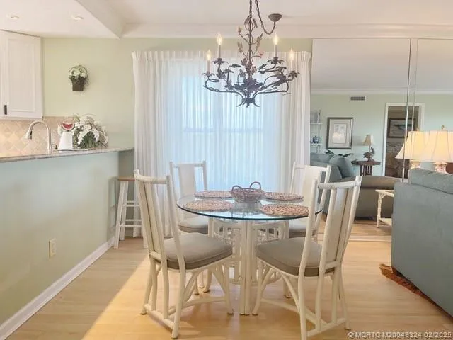 a view of a dining room with furniture a chandelier and wooden floor