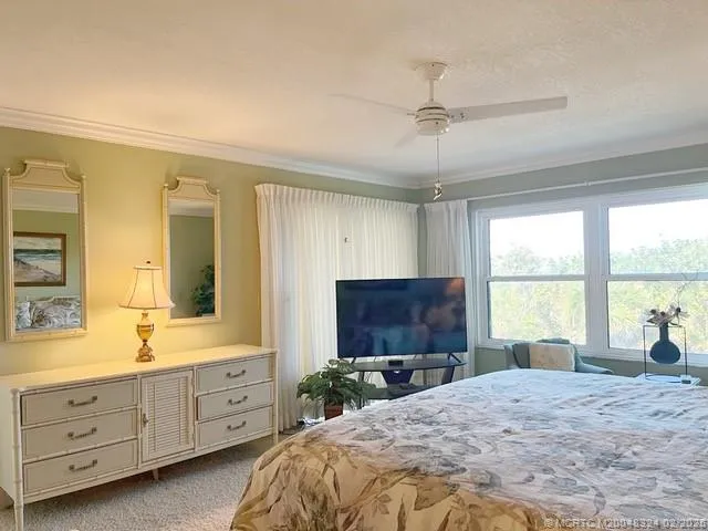 a bed room with a bed a window and a television