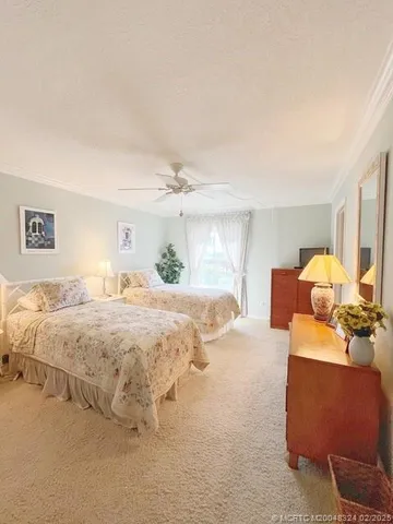 a bedroom with two beds and potted plant