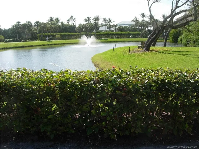 an aerial view of a house with green space and lake view