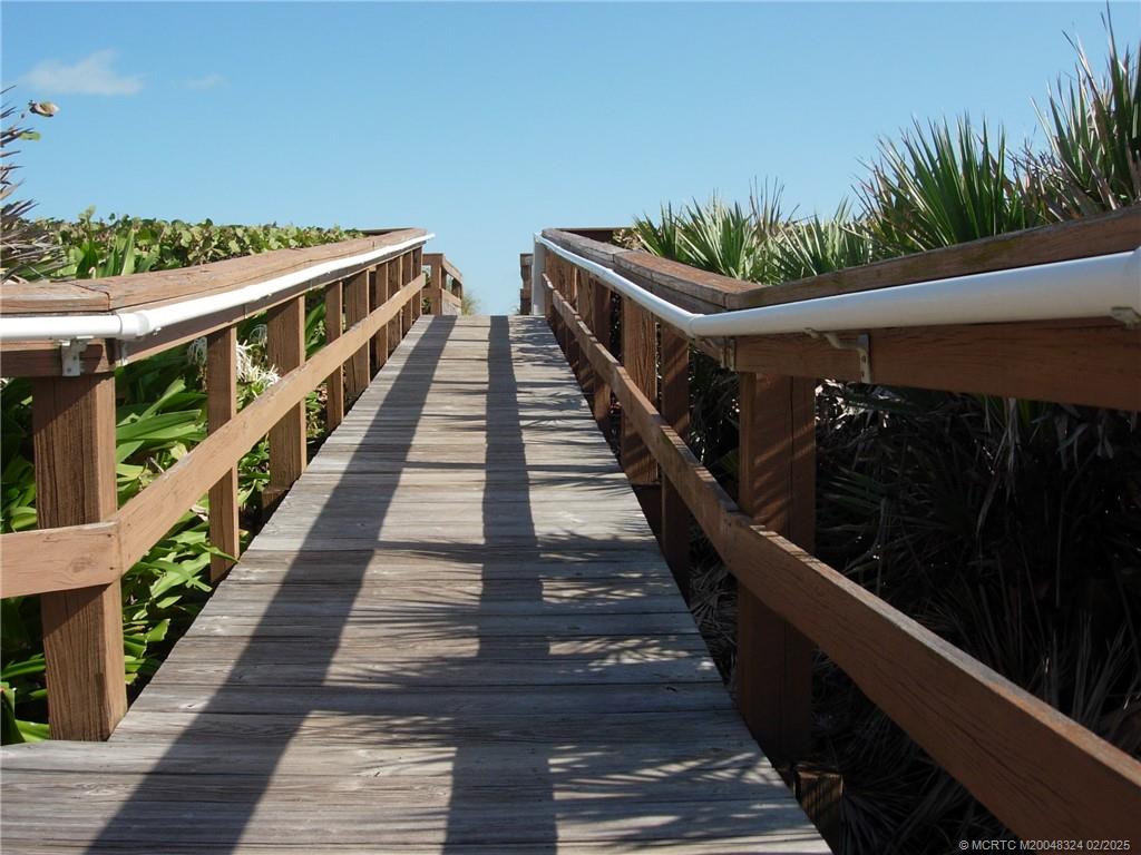 2641 Northeast Ocean Boulevard, Unit 201 Stuart, FL 34996 - Photo 6 of 34 a view of a balcony with wooden floor and stairs