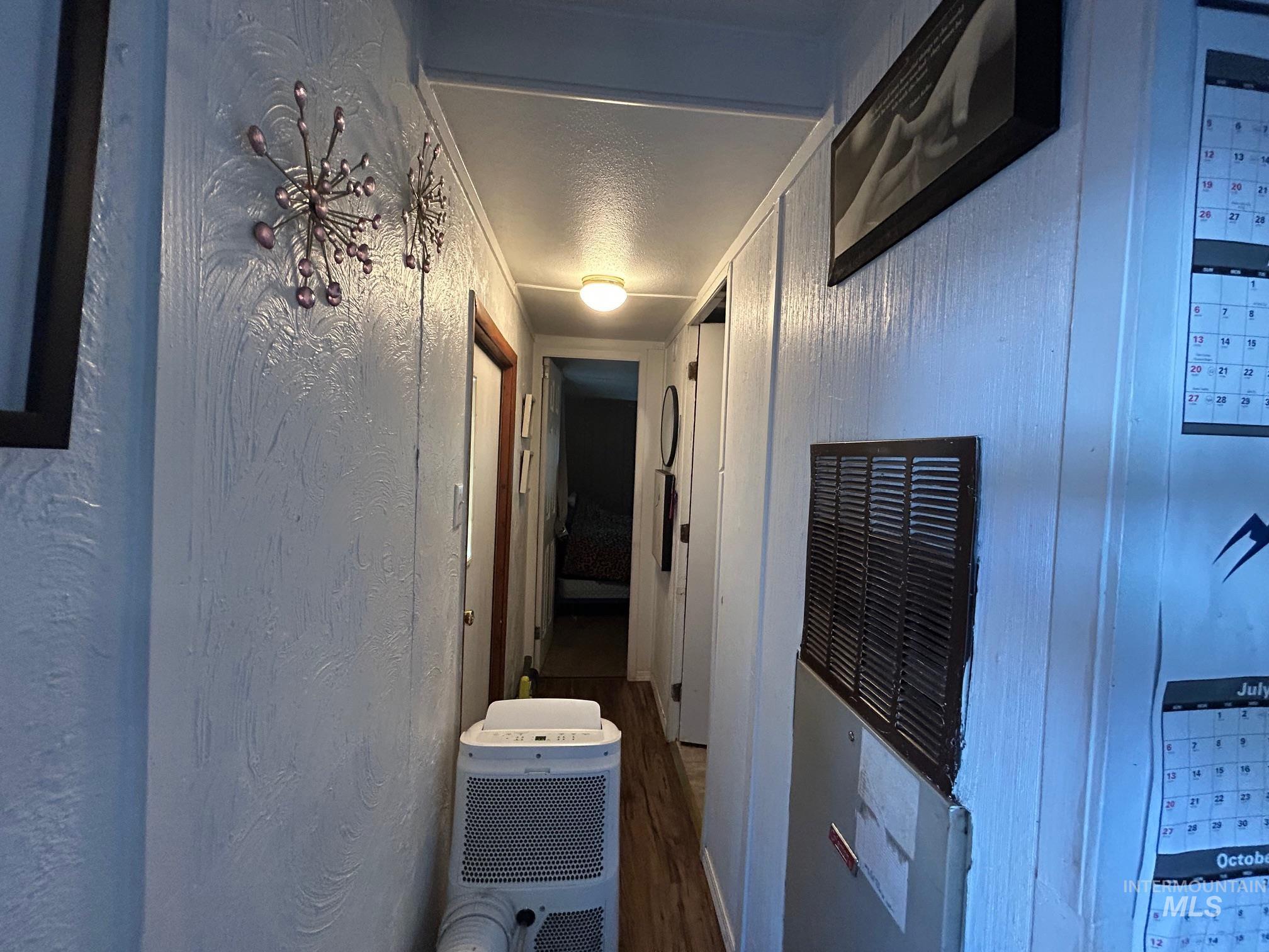 1383 Fair Street, Unit 5 Clarkston, WA 99403 - Photo 14 of 16 Hallway featuring a heating unit, dark wood finished floors, a textured wall, and a textured ceiling