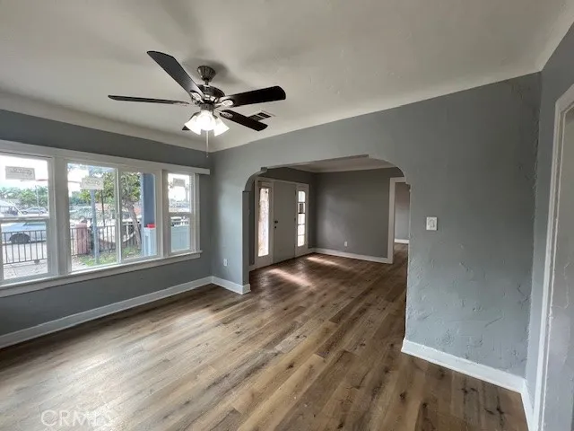 a view of an empty room with a window and wooden floor