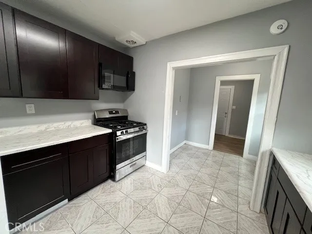 a kitchen with stainless steel appliances granite countertop a stove a microwave and a sink