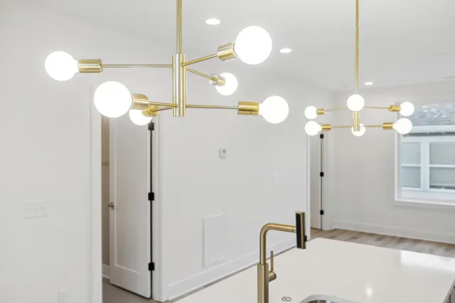a kitchen with a stove chandelier and wooden floor