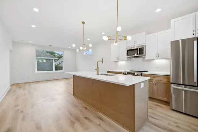 a kitchen with kitchen island a sink stainless steel appliances and window