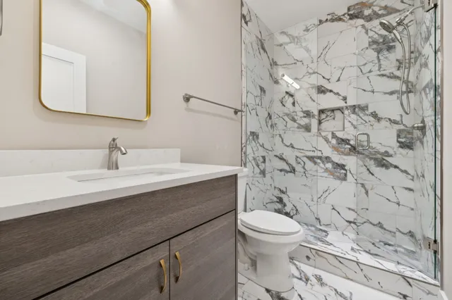 a bathroom with a sink a toilet and a mirror