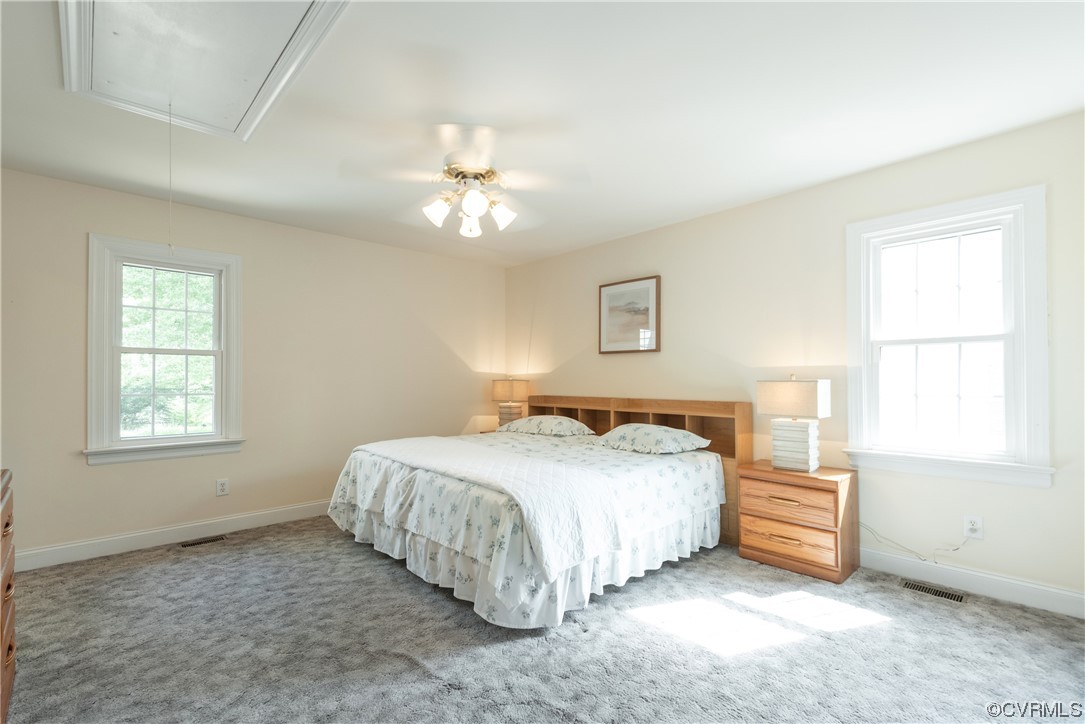 7508 Donder Road Richmond, VA 23294 - Photo 22 of 38 a bedroom with a bed next to a window and a chandelier
