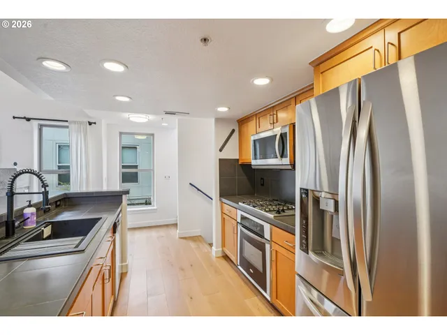 a kitchen with stainless steel appliances granite countertop a refrigerator stove and sink
