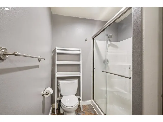 a bathroom with a toilet and a shower