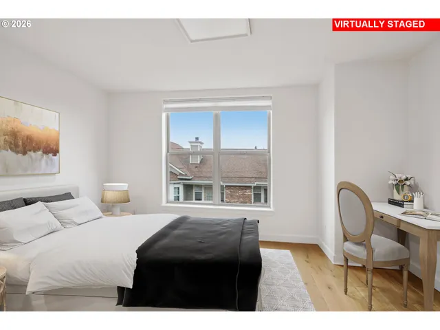 a bedroom with a bed a table and painting on the wall