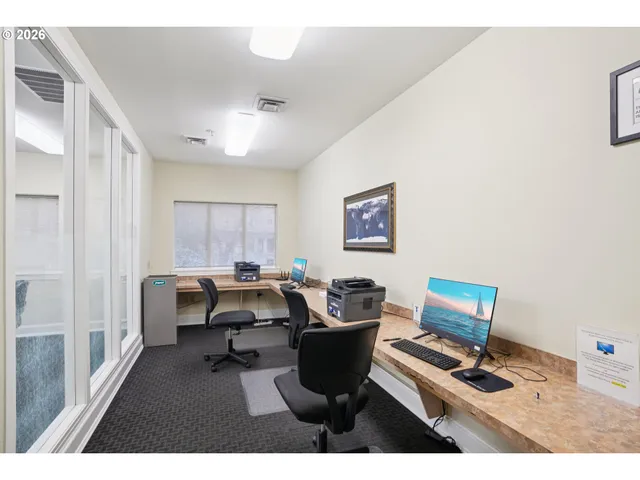 a view of a workspace with furniture and a window
