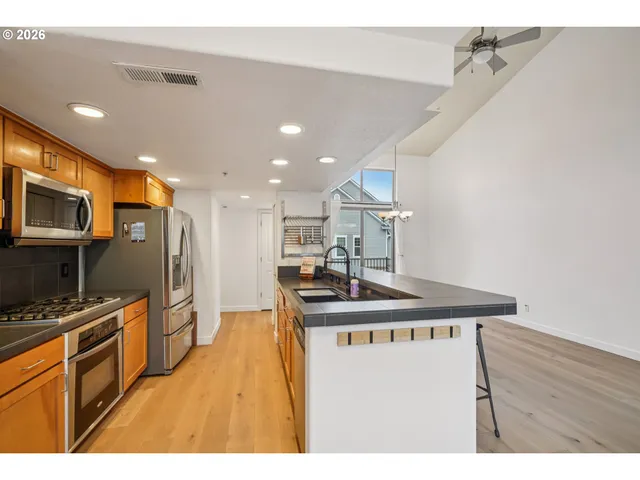 a kitchen with stainless steel appliances granite countertop a sink a stove and a refrigerator