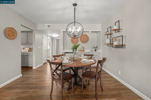 a view of a dining room with furniture a chandelier and wooden floor
