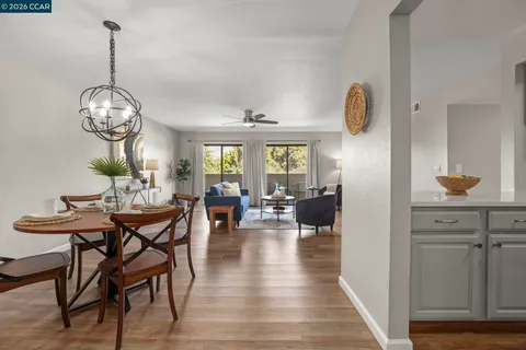 a view of a dining room and livingroom with furniture wooden floor a chandelier