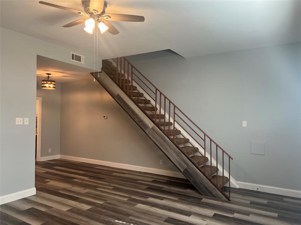 3121 Rosedale Avenue University Park, TX 75205 - Photo 7 of 16 Open-concept living area featuring wood-finish flooring, a contemporary ceiling fan, and a staircase with metal railings and carpeted treads.This modern look is what is planned for the renovations.