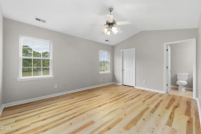 a view of empty room with window and wooden floor